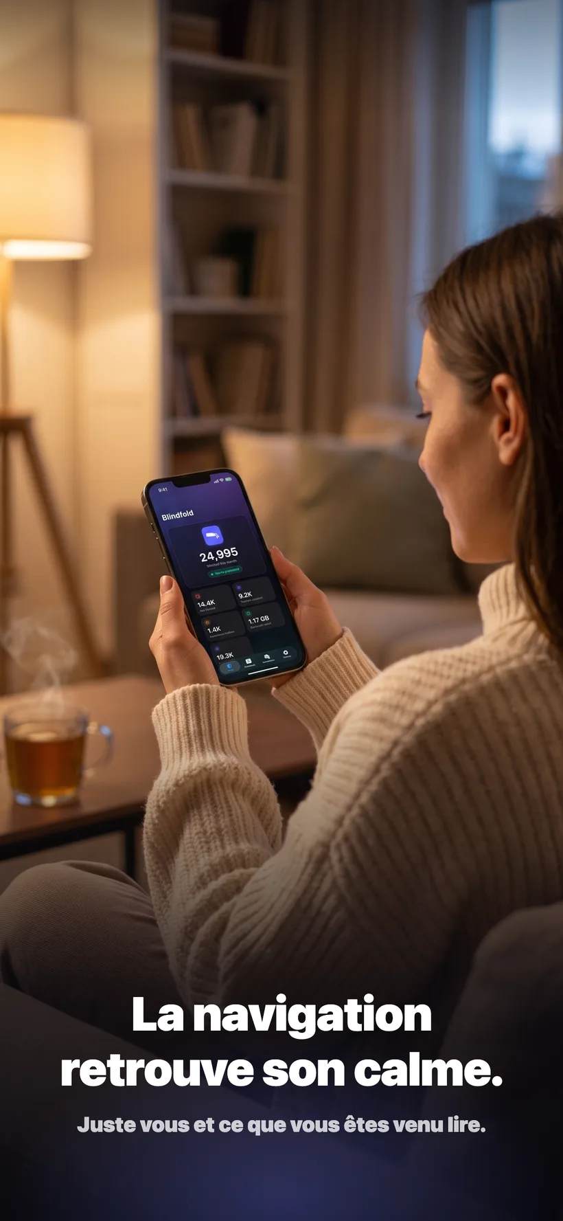 Une femme se détendant sur un canapé en soirée, lisant sur son iPhone avec l'application Blindfold ouverte affichant ses statistiques de blocage du mois.